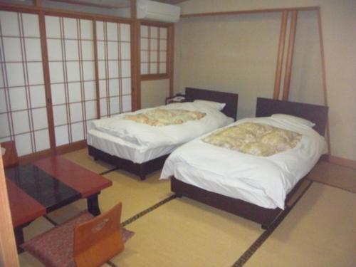 a room with two beds and a table in it at Yumura Onsen Tomiya - Vacation STAY 81727v in Yumura