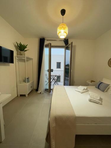 una camera con letto e vista su un balcone di Anemos Apartments Marsala a Marsala