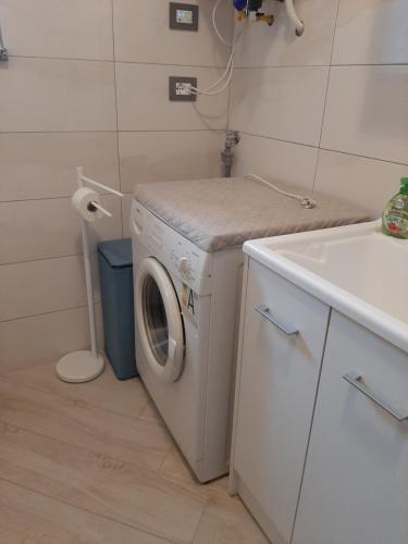 a laundry room with a washing machine and a sink at Appartamento Anto vicino al lago ai servizi al centro in Levico Terme