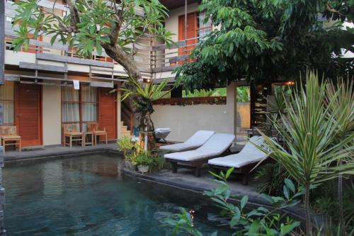 ein Resort mit einem Pool, Stühlen und Bäumen in der Unterkunft Semarandana Bedrooms and Pool in Sanur