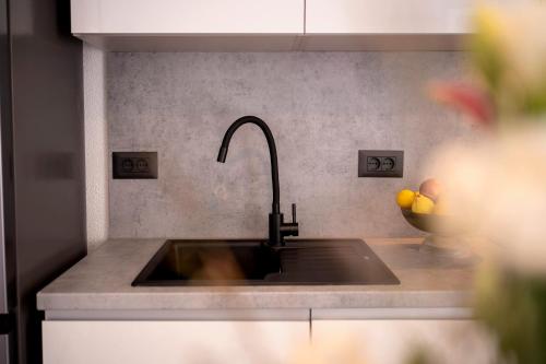 a kitchen sink with a faucet and a bowl of fruit at Secluded Sea View House - 10m from the Sea in Gdinj