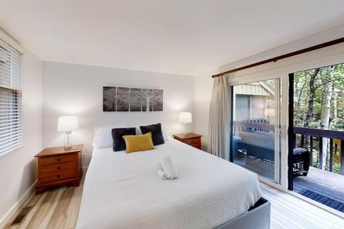 una camera con un grande letto e una grande finestra di Whispering Woods Retreat a Sapphire
