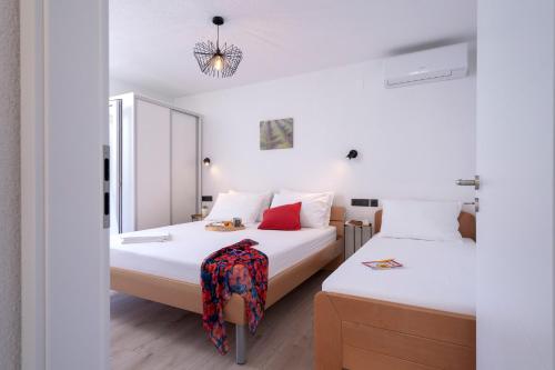 a bedroom with two beds and a mirror at Secluded Sea View House - 10m from the Sea in Gdinj