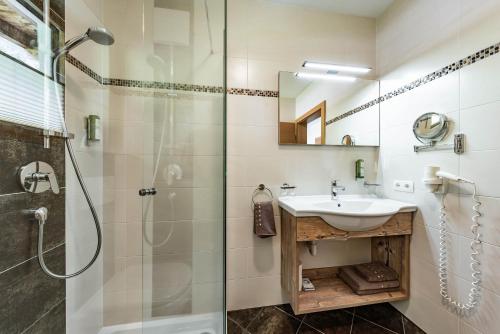 a bathroom with a sink and a shower at Landhaus Ifangl in Mayrhofen
