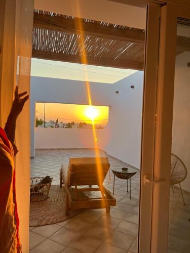 a person looking out a door at a sunset at Thermes private suites in Loutraki