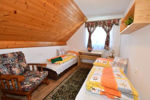 Una habitación con 2 camas y una silla en una habitación en PRIVAT MARIANNA en Žakovce