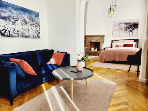 een woonkamer met een blauwe bank en een tafel bij The- POINT- 3BR Bright Cloud in Boekarest