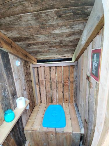 a small room in a wooden house with a blue toilet at Captain's Hideout in Skomakareidet