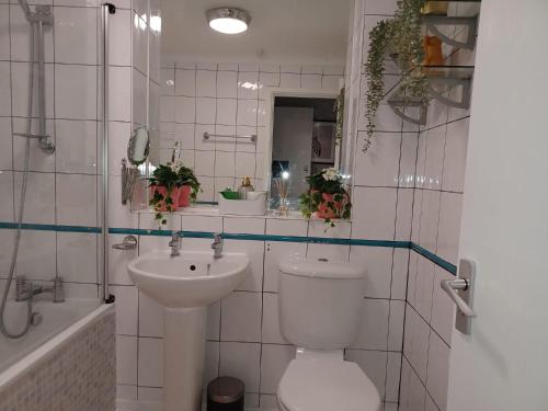 a white bathroom with a toilet and a sink at Green Door-The Malting- Specious 1st Floor-One Bedroom Apartment -Fully Furnished-Quiet- Free Parking -Dunstable in Dunstable