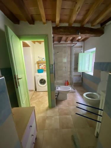 a bathroom with two toilets and a washing machine at La casina delle bimbe in Santa Luce