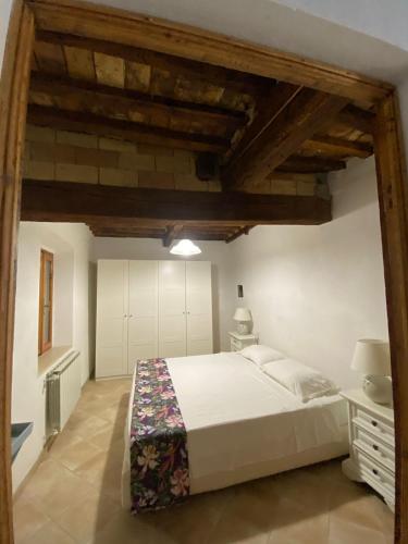 a bedroom with a large white bed and wooden ceilings at La casina delle bimbe in Santa Luce