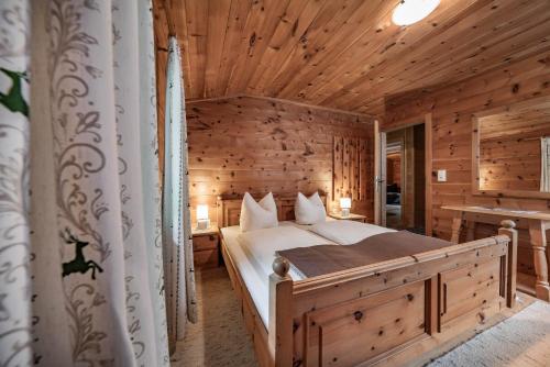 マイヤーホーフェンにあるHolzknechthütteの木造キャビン内のベッド1台が備わるベッドルーム1室を利用します。