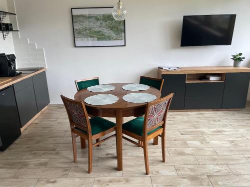 einen Esstisch mit Stühlen und eine Küche in der Unterkunft Apartamenty Stronie Śląskie in Stronie Śląskie