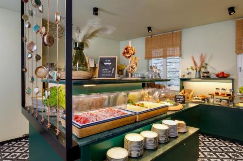 a buffet line with food on display in a restaurant at Hotel Das Regensburg in Regensburg