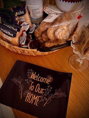 a welcome to our home sign next to a basket of food at Le Dimore in Piazzetta in Massafra