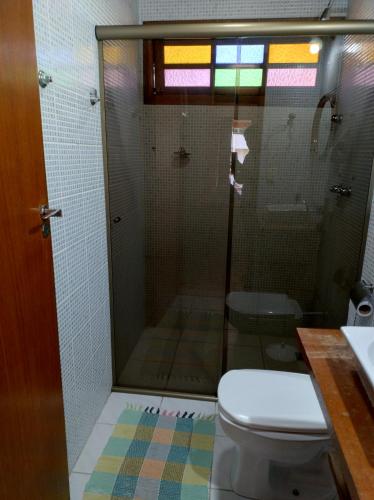 a bathroom with a shower with a toilet and a sink at Pousada Nova Conquista in Penedo