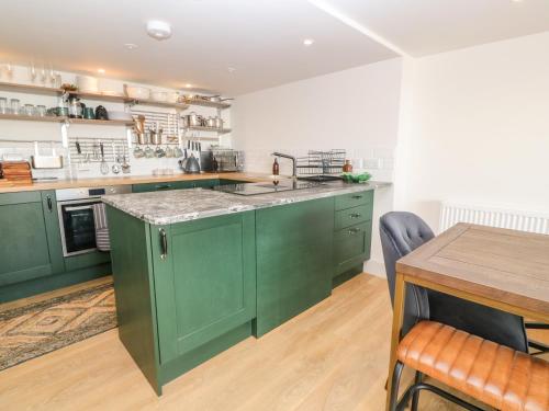 a kitchen with green cabinets and a wooden table at 16 Arwenack Street in Falmouth