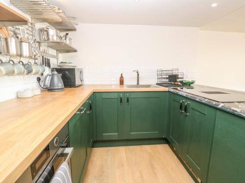 a kitchen with green cabinets and a sink at 16 Arwenack Street in Falmouth