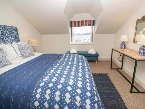 a bedroom with a blue and white bed and a window at 16 Arwenack Street in Falmouth