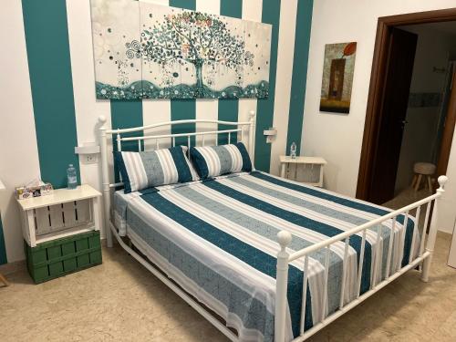 Schlafzimmer mit einem Bett mit blauen und weißen Streifen in der Unterkunft APP. TURISTICO ARCO NORMANNO in Mazara del Vallo