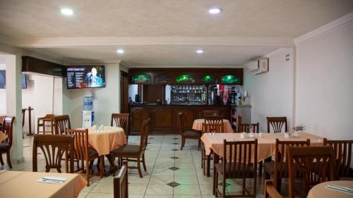 a restaurant with tables and chairs and a bar at Hotel Casino Plaza in Guadalajara