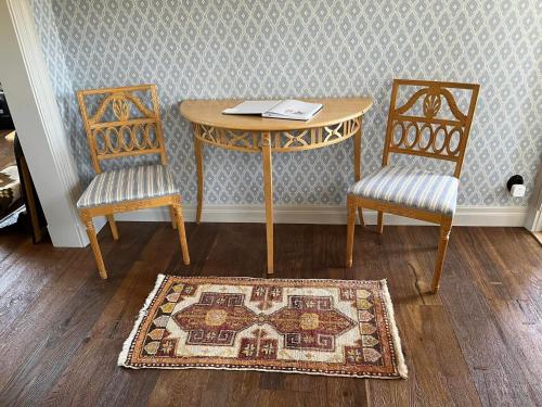 mesa con 2 sillas y mesa con alfombra en Lovisas Stuga en Vadstena