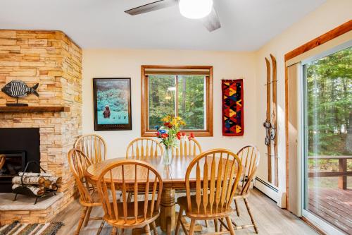 a dining room with a table and chairs and a fireplace at Northwoods Paradise in Eagle River