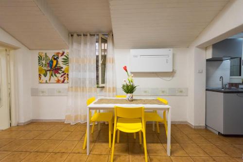 uma cozinha com uma mesa e cadeiras amarelas em Casa Vacanze Basso em Salerno