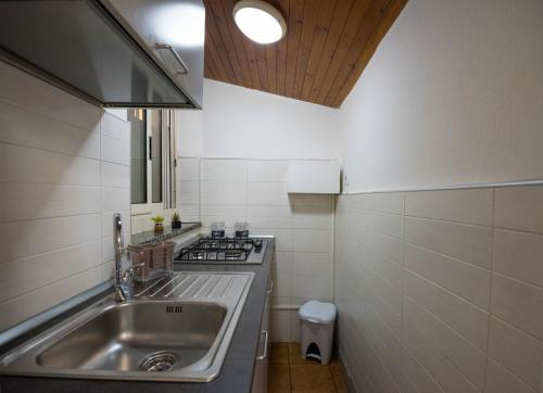 uma pequena cozinha com um lavatório e um fogão em Casa Vacanze Basso em Salerno