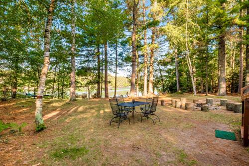 a picnic table in the middle of a park with trees at Northwoods Paradise in Eagle River