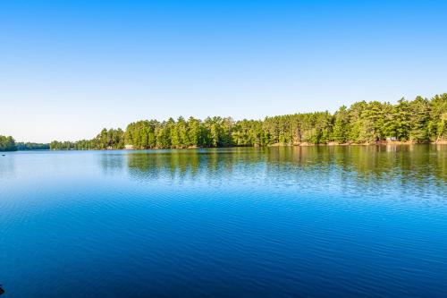 a large blue lake with trees in the background at Northwoods Paradise in Eagle River