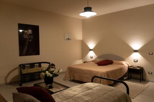 una camera d'albergo con due letti e un divano di Tenuta I Gelsi a Benevento