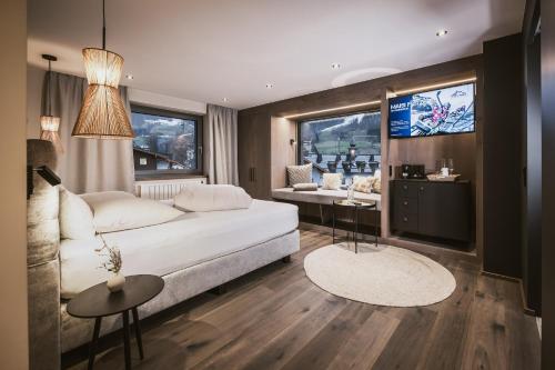a living room with a white couch and a tv at Margarethenstein Boutique Hotel in Kaprun