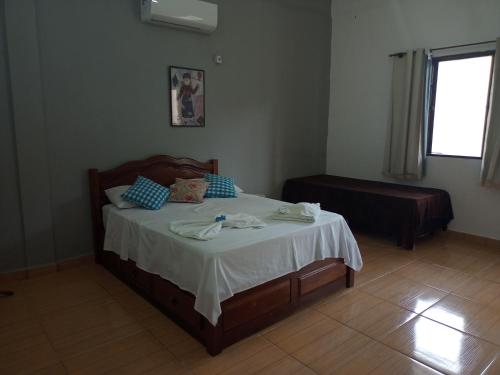 a bedroom with a bed with towels on it at Pousada Nova Conquista in Penedo