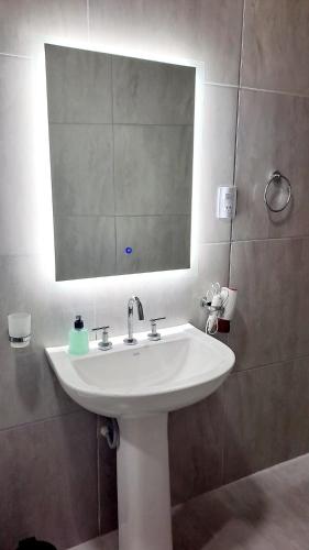 a bathroom with a white sink and a mirror at Casa Valle Viejo con Cochera Cubierta Gratis in San Fernando del Valle de Catamarca