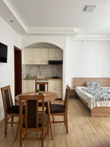 a kitchen and dining room with a table and a bed at Apartments Božinović in Soko Banja