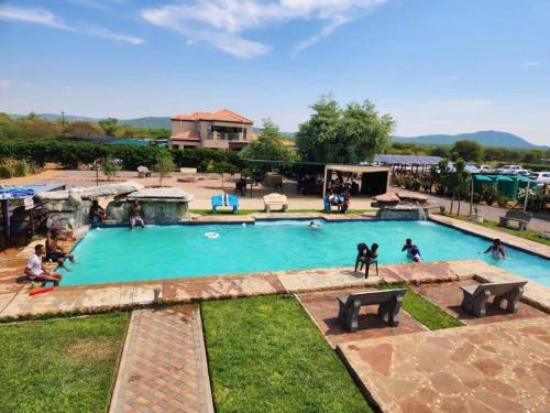 uma grande piscina com pessoas a brincar nela em Tlokweng Rose Garden Guesthouse em Gaborone