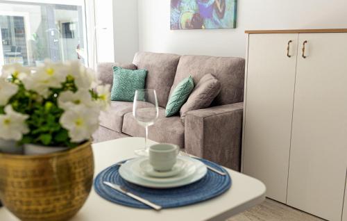 a living room with a couch and a table with wine glasses at Mar Apartments Alicante, Playa de San Juan in Alicante