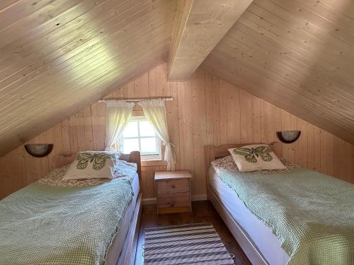 a attic bedroom with two beds and a window at Villa Vita in Seimėnai