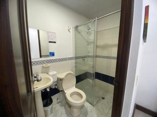 a bathroom with a toilet and a sink and a shower at Hotel Malecon Puerto Berrio in Puerto Berrío