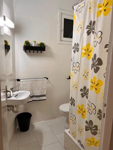 a bathroom with a shower curtain with a sink and a toilet at Studio de charme rénové - Fibre- Centre Rabat in Rabat