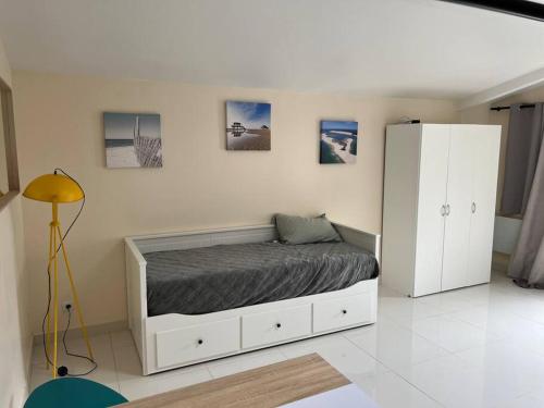 - une chambre avec un lit et une armoire blanche dans l'établissement Le petit paradis, à Gujan-Mestras
