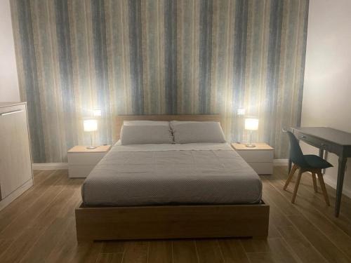 a bedroom with a bed and a desk with two lamps at Il Pavone in Taranto