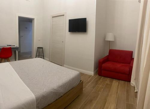 a bedroom with a bed and a red chair at Il Pavone in Taranto