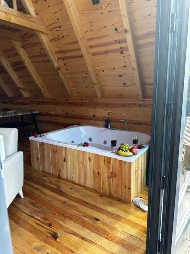 a large tub in a room with a wooden ceiling at Yamaçdere Bungalov in Ardeşen