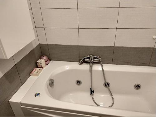 a bath tub with a faucet in a bathroom at Red House Tiburtina in Rome