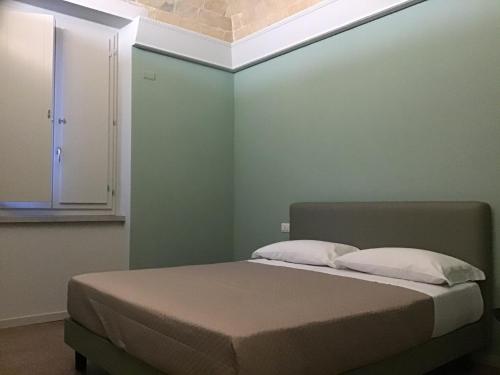 Cama en habitación con pared verde en VILLA ACTEA, en Vasto