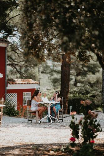 two women sitting at a table in a garden at Le Cigalon in Le Beausset