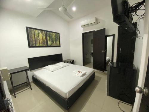 a bedroom with a bed and a television in it at Hotel Malecon Puerto Berrio in Puerto Berrío