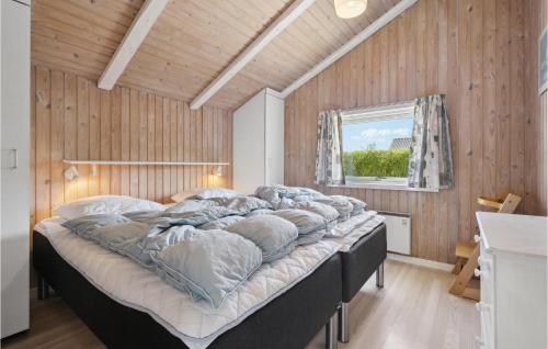 een groot bed in een kamer met houten wanden bij Stunning Home In Sydals With Wifi in Skovby
